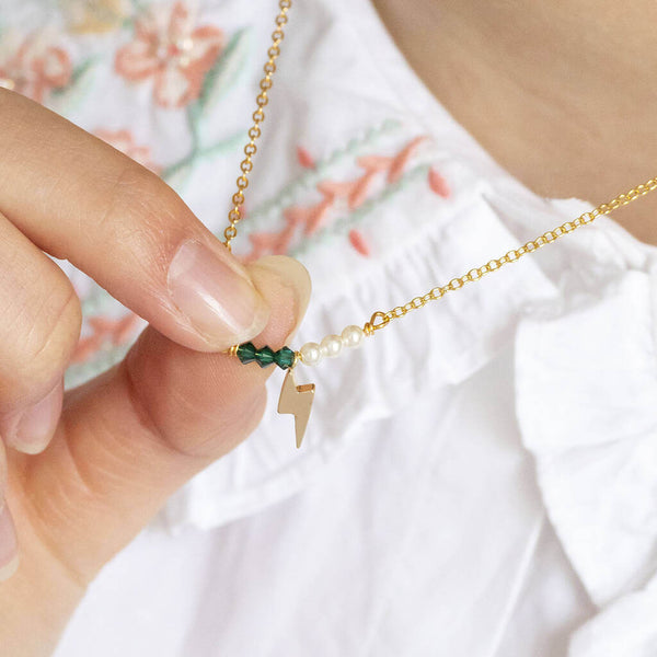 Image shows model holding Lightning Bolt Birthstone and Pearl Bar Necklace