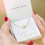 Image shows model holding lotus flower purity symbol bracelet in a gift box on a just because sentiment card
