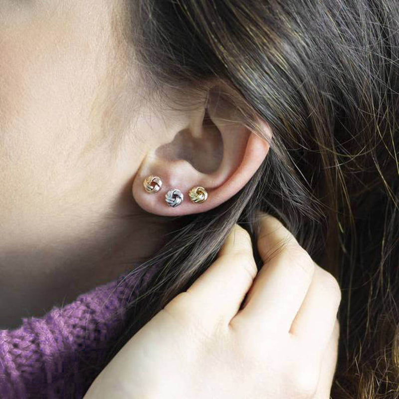 Image shows model wearing rose gold, silver and gold Love Knot Stud Earrings