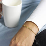 Image shows model wearing gold Mama Bracelet