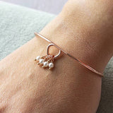 Image shows model wearing rose gold milestone birthday pearl charm bracelet with 4 pearls