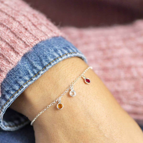 Image shows model wearing mini family birthstone charm bracelet 
