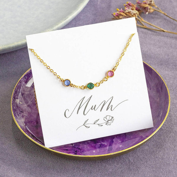 Image shows Mini Gold Plated Family Birthstone Link Necklace on s Mum sentiment card sitting in a purple trinket dish