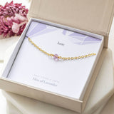 Image shows gold Minimalist June Birthstone Single Bead Bracelet in a gift boson a June birthstone characteristic card