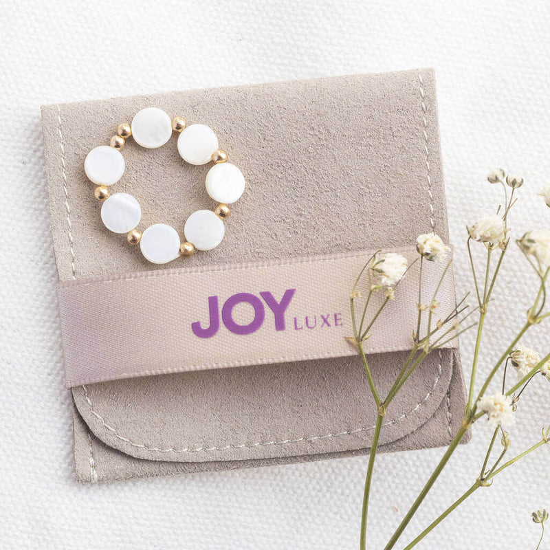 Mother of pearl disc stretch ring sitting on the JOY suede pouch 