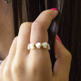 Model wears mother of pearl heart stretch ring as she hold her hai