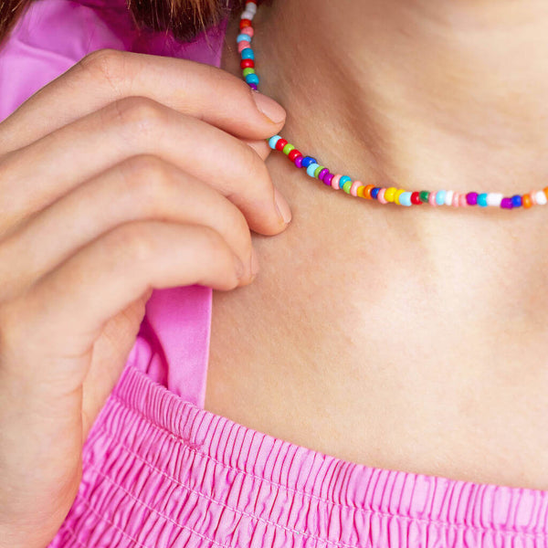 Image shows model wearing multi coloured beaded necklace
