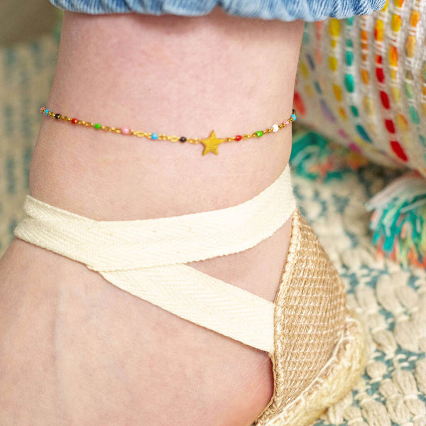 Model wears multicoloured beaded star anklet.