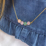 Image shows the model wearing personalised enamel disc name necklace with the name Cara