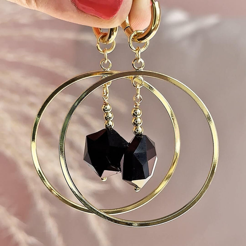Image shows model holding Oversized Circle Black Crystal Hexagon Earrings