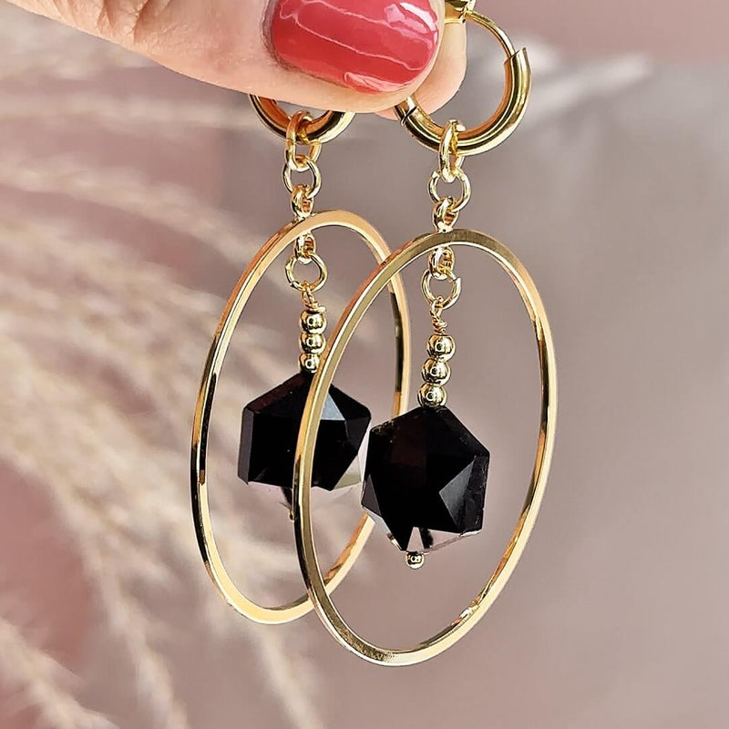 Image shows model holding Oversized Circle Black Crystal Hexagon Earrings
