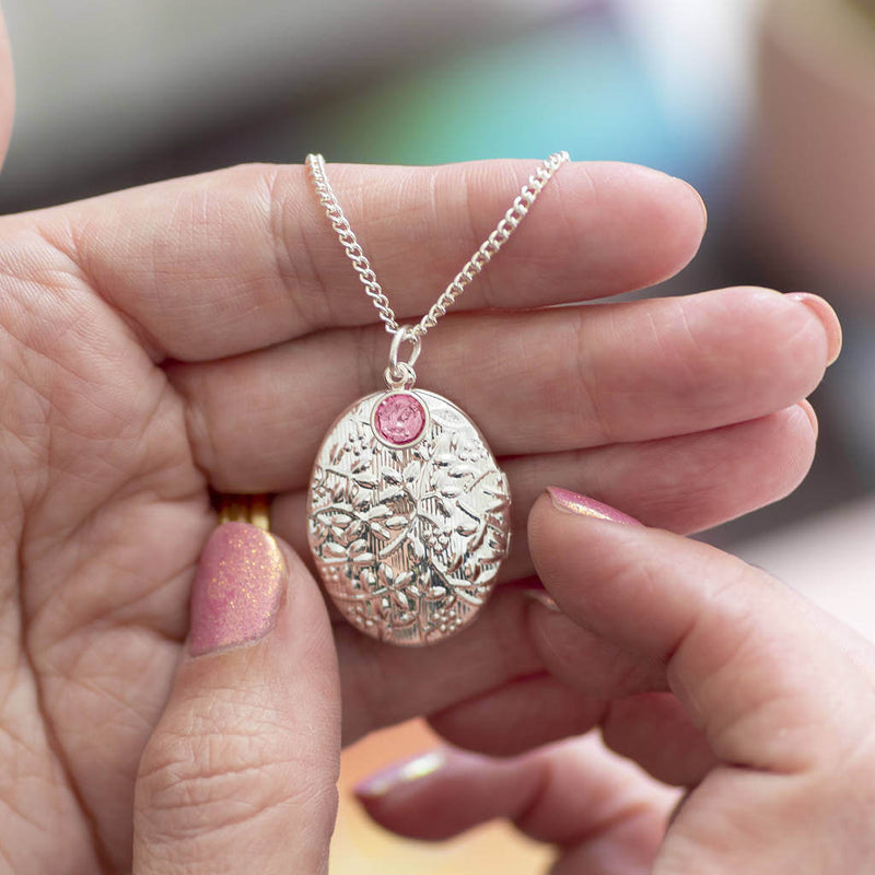 Image shows model holding Oversized Oval Birthstone Locket Necklace with October birthstone