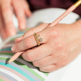 Image shows model wearing gold pave star beaded charm ring with March birthstone