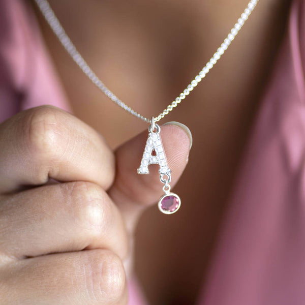 Model wearing silver pearl alphabet necklace with October(Rose pink) birthstone attached