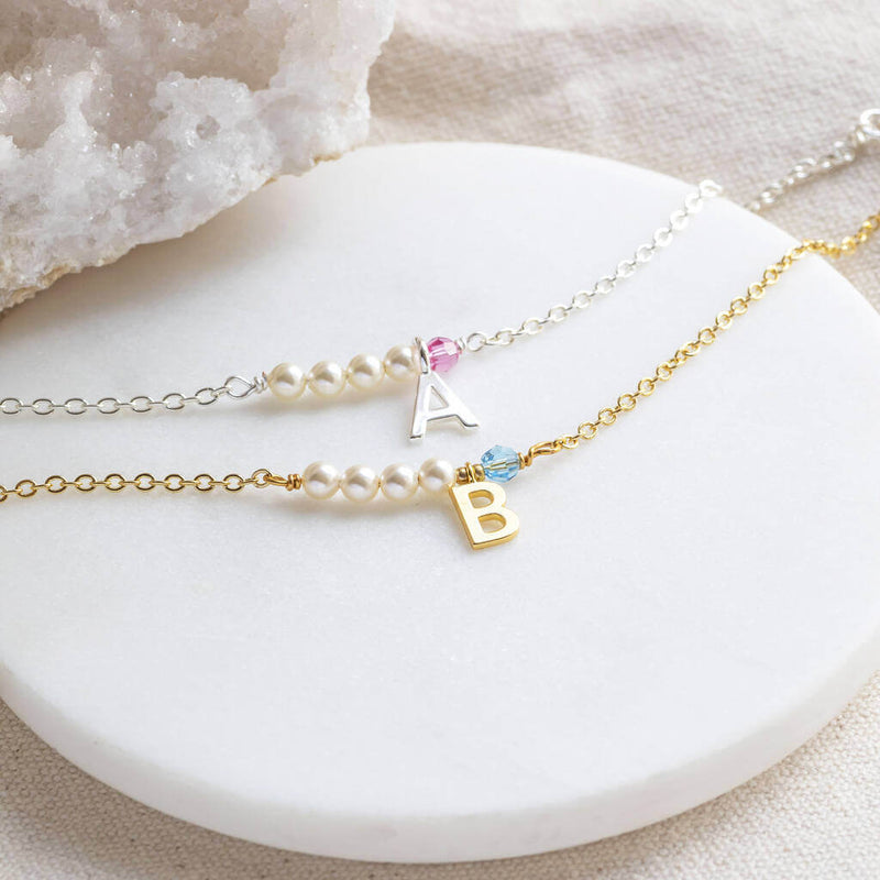 Image shows silver and gold pearl and birthstone initial bar bracelets  
