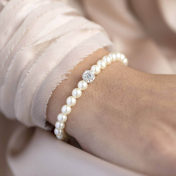 Model wears pearl and crystal glitter ball bracelet next to pine sleeve