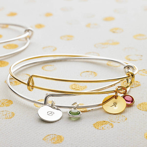 Image shows silver and gold personalised birthstone bangles 