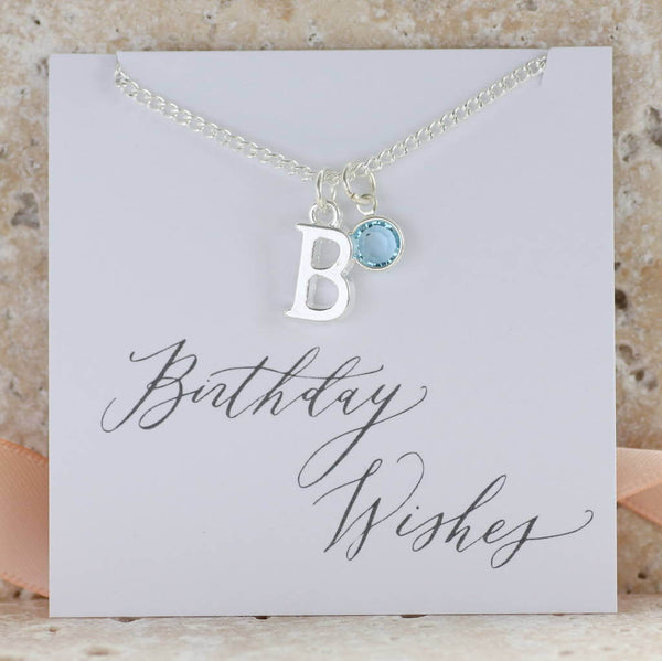 Image shows personalised birthstone charm necklace with the initial B and March birthstone on a birthday wishes sentiment card