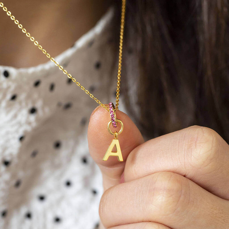 Images shows model wearing personalised birthstone ring initial necklace with the initial A and February birthstone ring