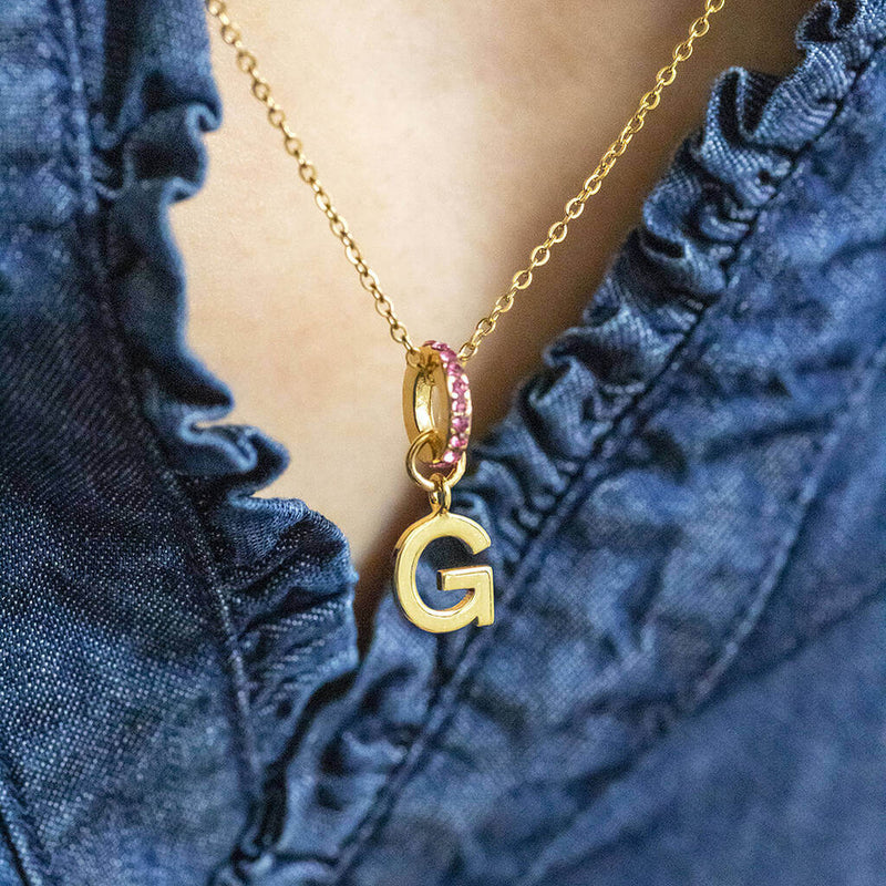 Images shows model wearing personalised birthstone ring initial necklace with the initial G and October birthstone ring