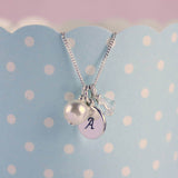 personalised bridesmaid charm necklace hanging from a blue and white polka dot cup
