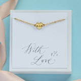 Image shows personalised dainty heart bracelet in a gift box on a with love sentiment card