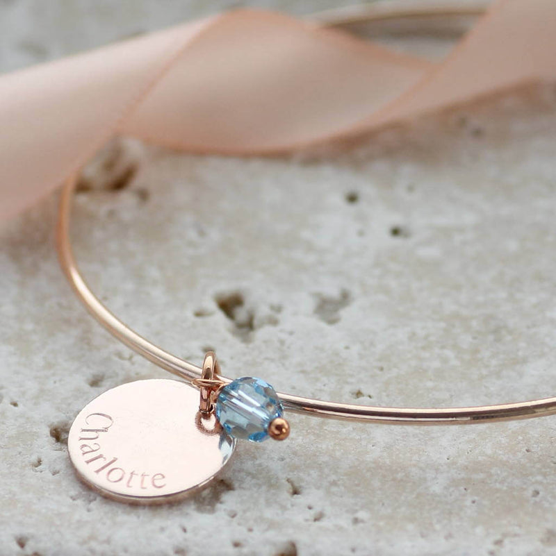 Image shows personalised engraved disc birthstone bangle with the name Charlotte  engraved and March birthstone