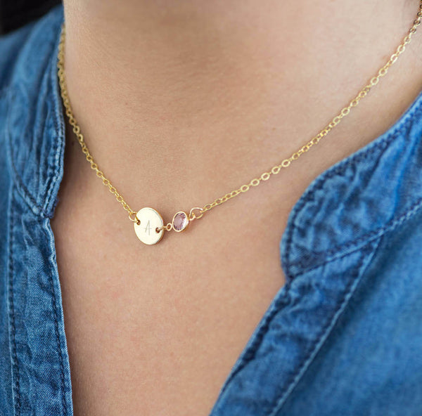 Image shows model wearing personalised gold disc birthstone necklace with Ai initial on disc and  June birthstone