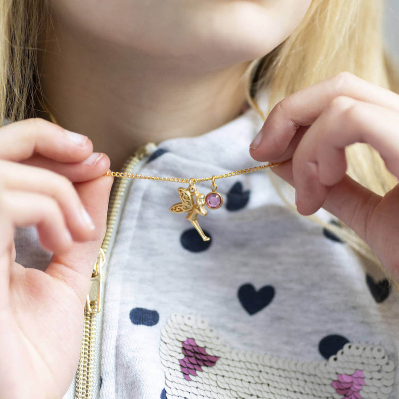 Image show model holding personalised gold fairy birthstone necklace with October birthstone