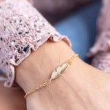 Image shows model wearing Personalised Gold Feather Bracelet