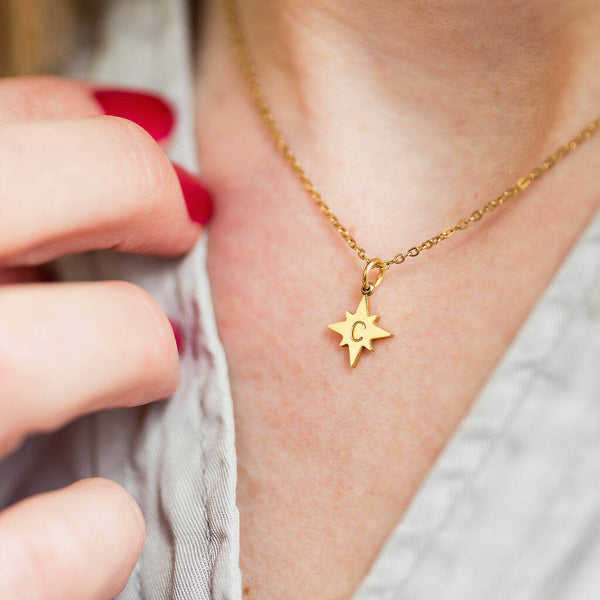 Image shows model wearing personalised guiding North Star necklace with the initial C engraved on the star