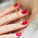Image shows model holding personalised guiding North Star necklace with the initial C engraved on the star