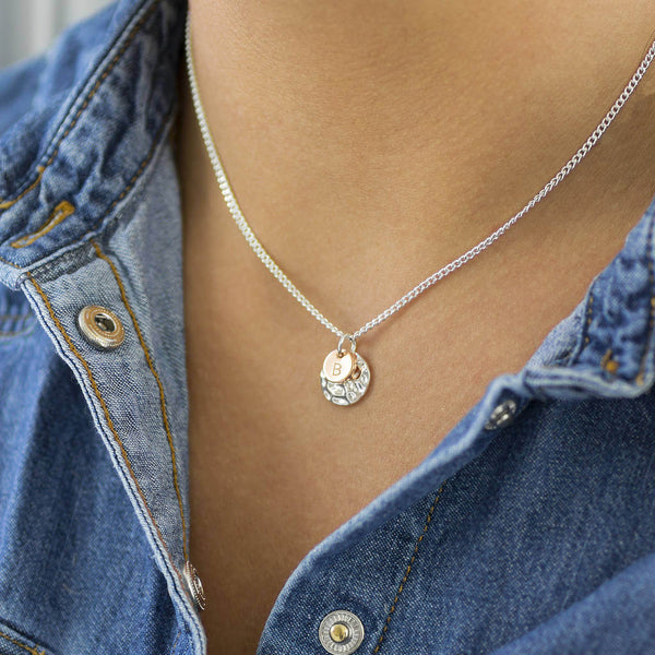 Image shows model wearing hammered disc necklace with initial disc B