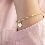 Image shows model wearing Personalised Heart Bracelet with Pearl Detail showing initial disc at clasp