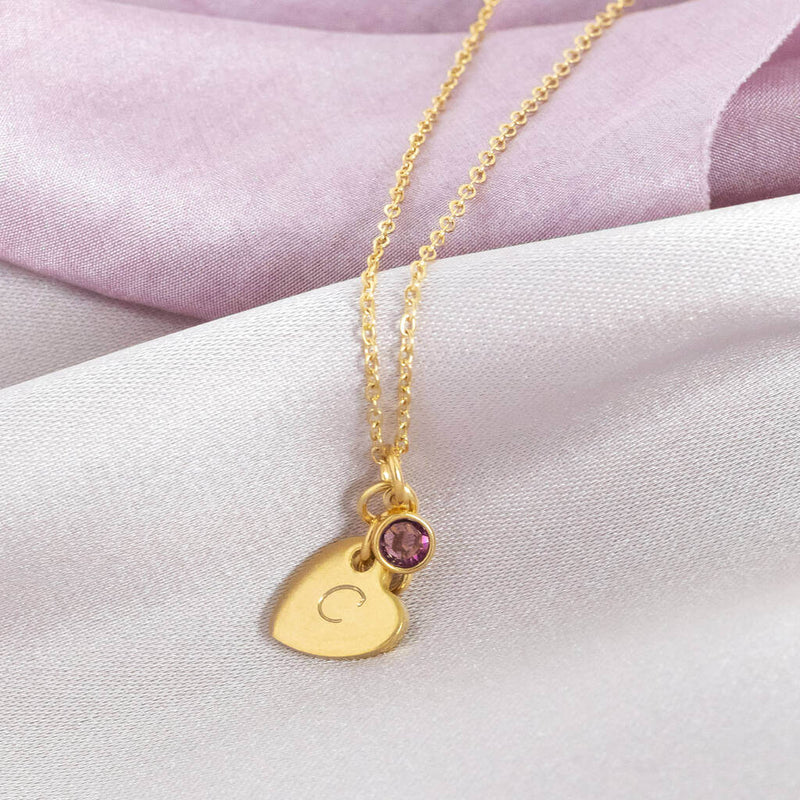 mage shows personalised heart of gold birthstone necklace with the letter C engraved the heart and February birthstone
