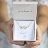 Model hold a  gift box with personalised infinity bracelet with pearl detail on with love sentiment card