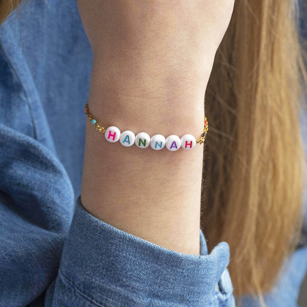 Image shows model wearing personalised name enamel chain bracelet with the name Hannah