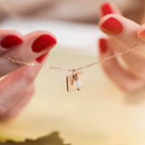 Image shows model holding personalised square charm necklace