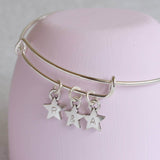 Image shows personalised stars charm bangle with 3 star charms