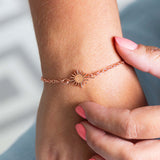 Image shows model wearing rose gold personalised sunburst  bracelet engraved with the initial C 