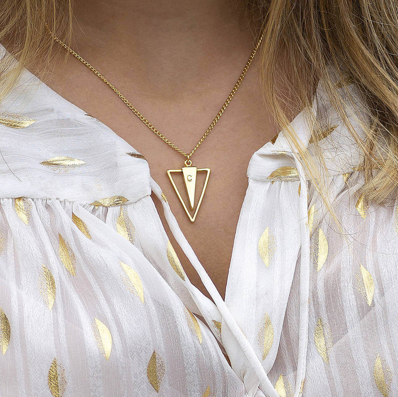 Image shows model wearing personalised triangle spike necklace with C initial on it