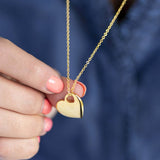 mage shows model holding Polished Gold Cut Out Heart Necklace