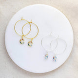 Image shows two pairs of  rainbow initial hoop charm earrings one pair gold with the initials c and  the other pair silver with the initials R