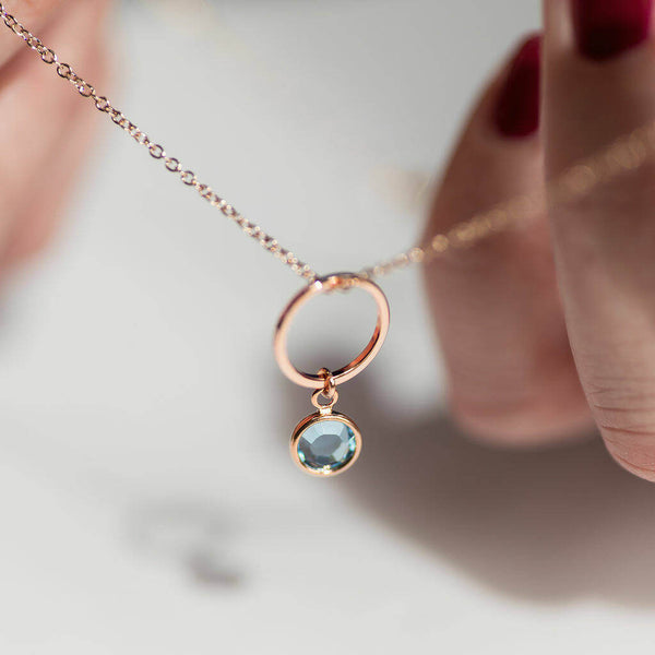 Image shows model holding Rose Gold Circle Necklace With Birthstone Charm