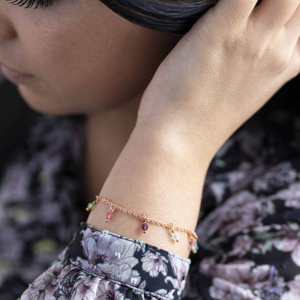 Image shows the model wearing rose gold family birthstone charm bracelet