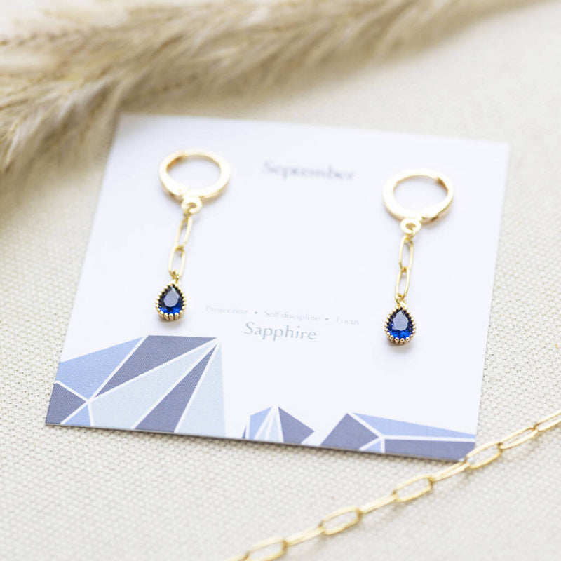 Image shows Sapphire September Birthstone Teardrop Dangle Earrings on September birthstone characteristic card