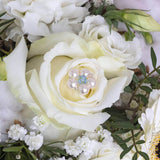 Image shows bridal bouquet with something blue pin