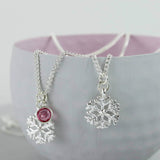 Image shows two silver snowflake birthstone charm necklace one with October birthstone 