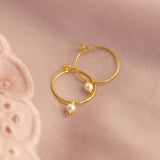 Image shows simple gold pearl hoop earrings