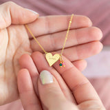 Image shows model holding 'Sisters' Heart Birthstone Necklace